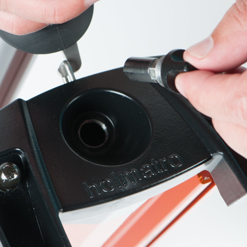 Nærbillede af justering af Holmatro pumpe med tydeligt logo og personens hænder.