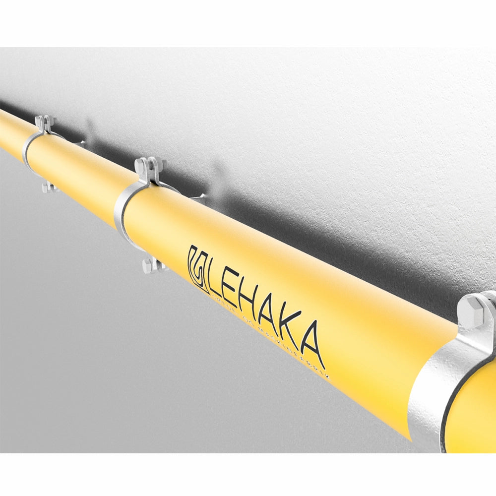 Gul metalrør med LEHAKA-logo fastgjort til væg med metalbeslag og bolte.