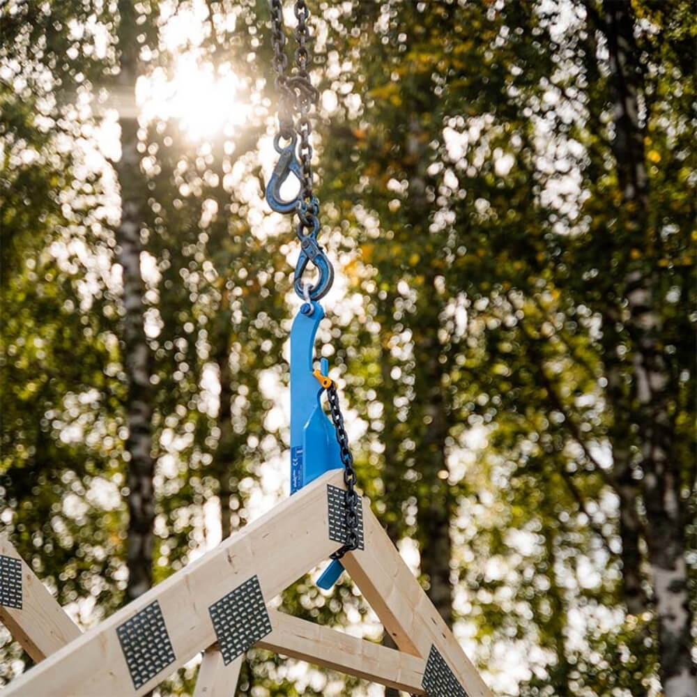 ALUEX Lifter 1.0 T i blå med sort kæde og krog, hængende foran træer i sollys.