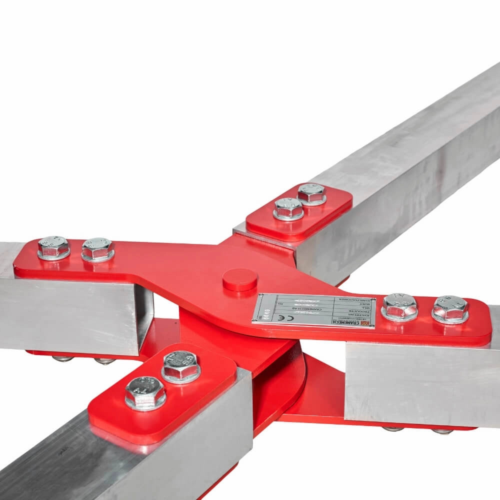 Metalstruktur med fire arme, sølv og rød, bolte og et skilt med specifikationer.