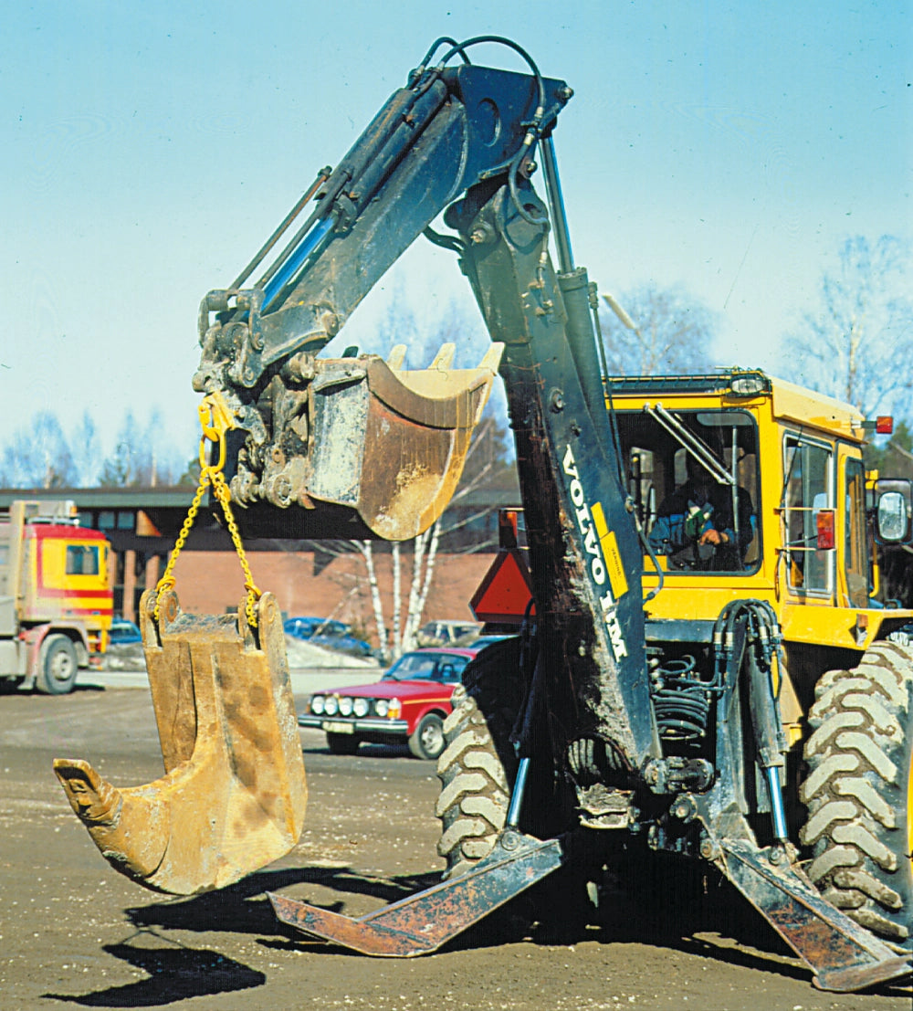 Gul Gunnebo-krog i brug på gravemaskine, løfter tungt objekt på byggeplads.