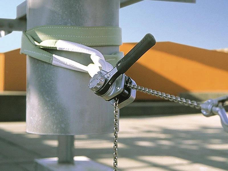 KITO Skraldetalje fastgjort til metalstang med rem og kæde udendørs.