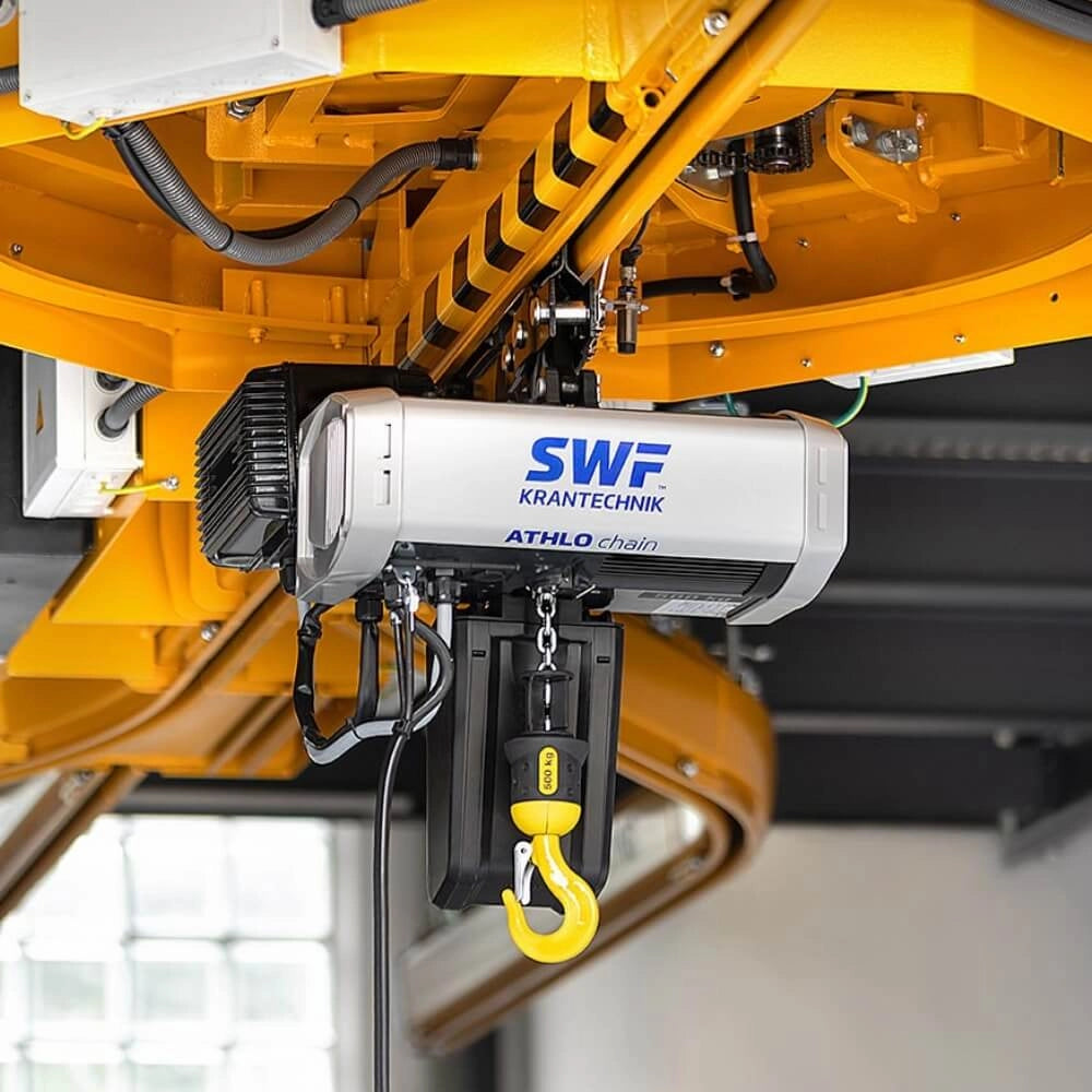 Elektrisk talje fra SWF Krantechnik med gul krog og kæde, monteret og mærket synligt.